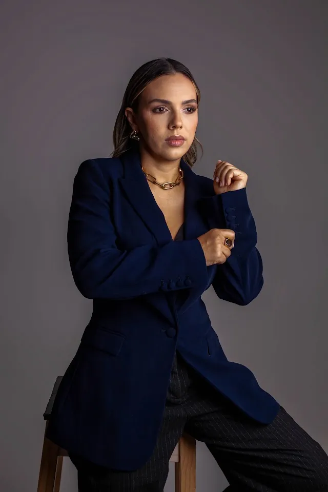 Paciente adulta em ensaio autorizado, com blazer azul-marinho e produção elegante